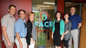 Six people standing in front of a business office for FACE