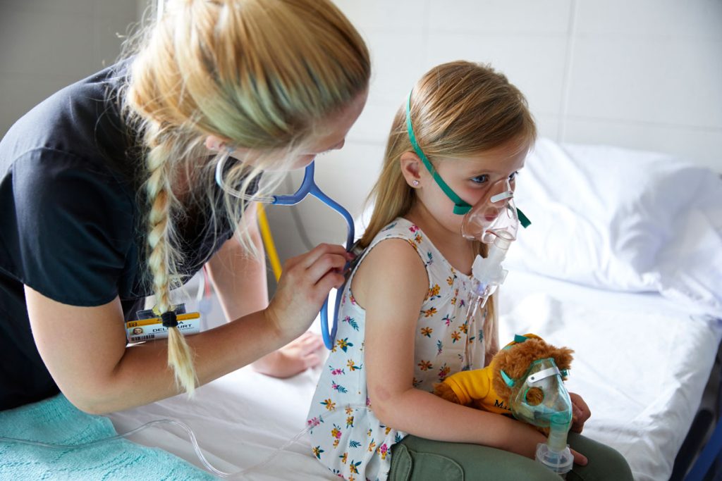 Respiratory therapy student uses stethoscope with pediatric patient