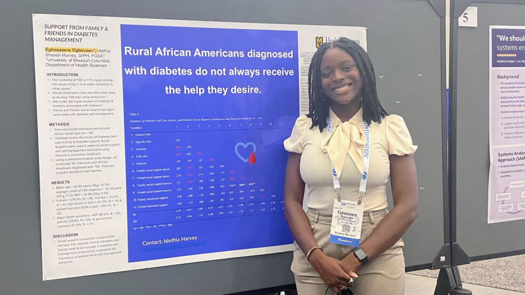 Health Sciences student Eghosasere Ogbevoen, stands in front of her research poster at American Public Health Association awards